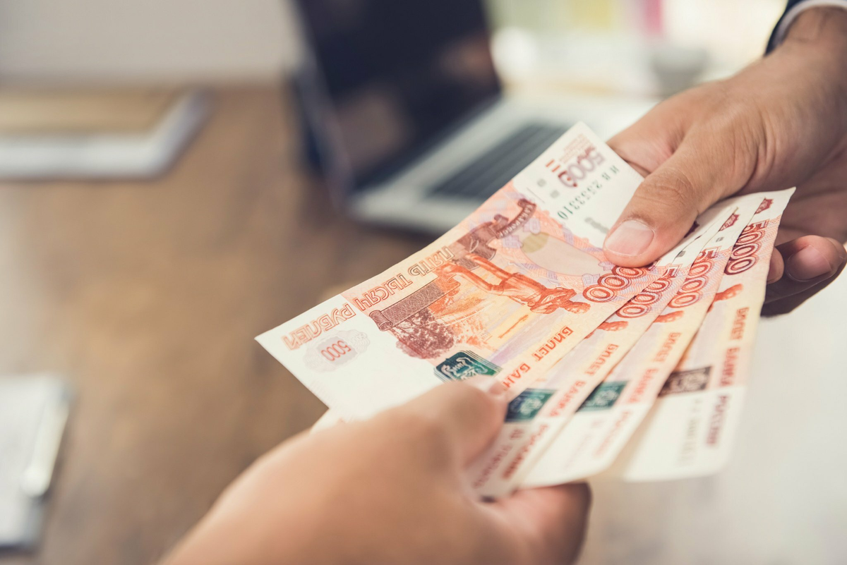 займ на карту. протягивает деньги. рубли в руках. заемные деньги. деньги в руках.