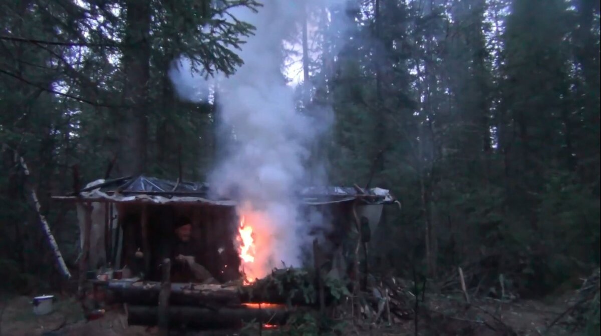 В видео: Красиво Дым в тайге Угли обжигают лицо Рабочий вариант нодьи Ночная Жизнь в Шалаше Проверились на энцефалитных клещей После дождя. В нодью достаточно подбросить одну сушинку и нодья весело работает. Носки постирали повешали на сушку на ноги одели чуни с дернита (дернитом отделяют мерзлоту от земли). О инфракрасном излучении от углей. Идет дождь значит тучи создают парниковый эффект и будет тепло. О том как ставить шалаш по отношению к костру. Медведь любопытный и активен в сумерки нодья стреляет и отпугивает медведя.