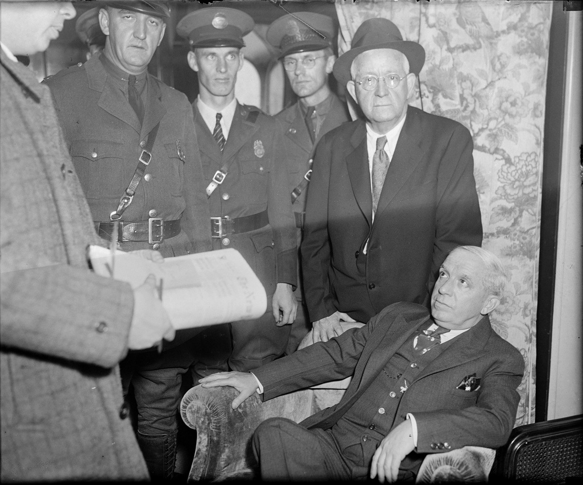 Чарльз Понци (в кресле) в ожидании депортации в Италию, 1934 год.