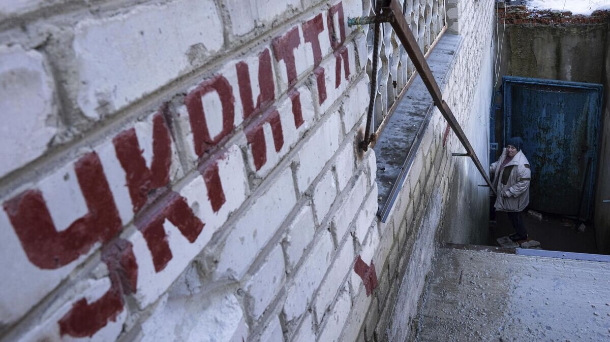    Женщина спускается в бомбоубежище во время воздушной тревоги на Украине © AP Photo / Evgeniy Maloletka