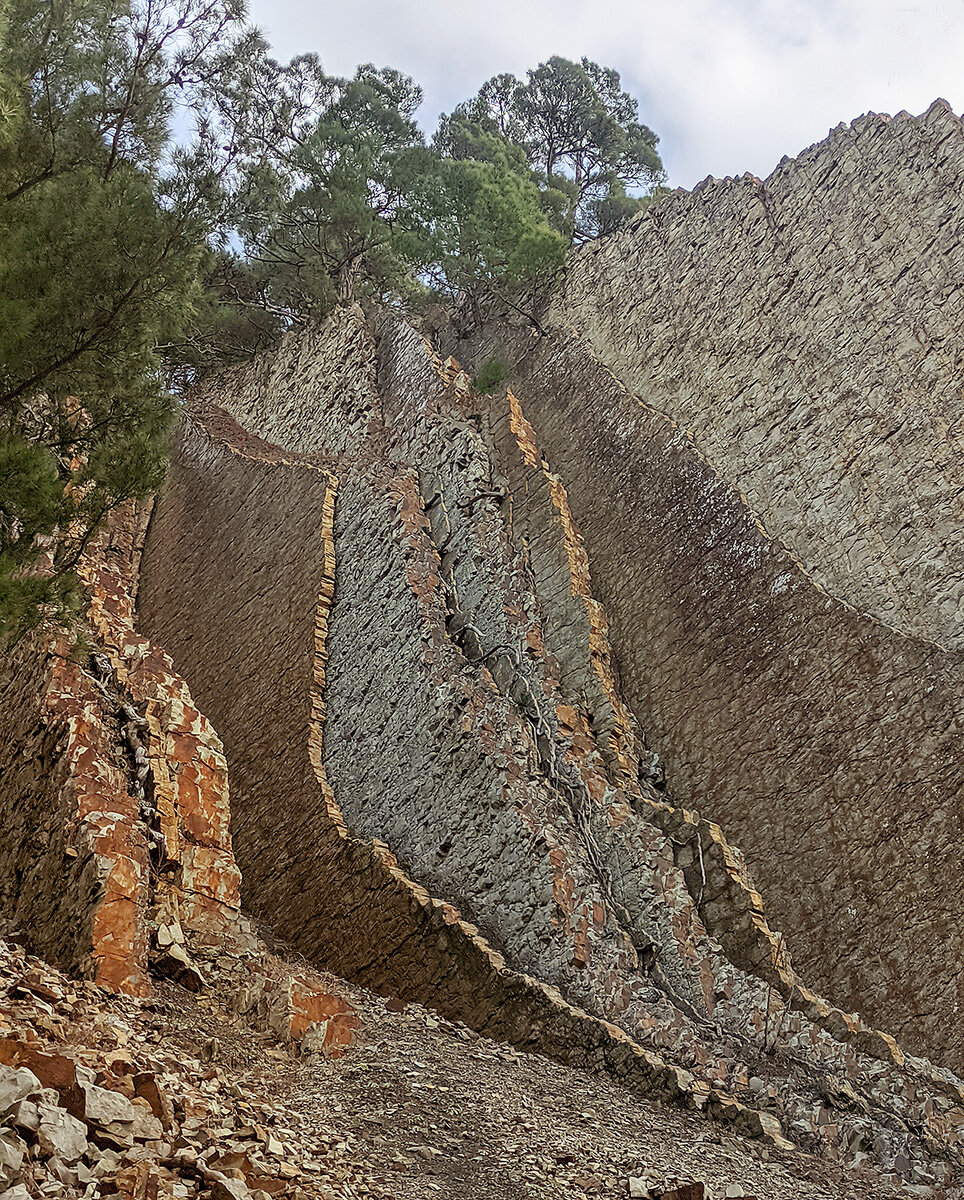 Пласты, уходящие вверх по склону. По сути это продолжение скалы.