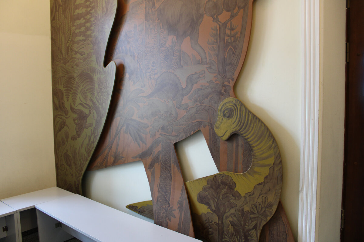 Брахиозавр у кассы музея, на теле которого изображены другие древние животные и растения