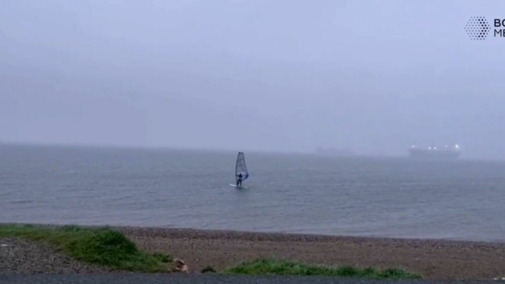     Несмотря на суровую погоду во Владивостоке неизвестный местный житель решил заняться виндсерфингом. Ливень, сильный ветер и холод не стали препятствием для спортсмена.