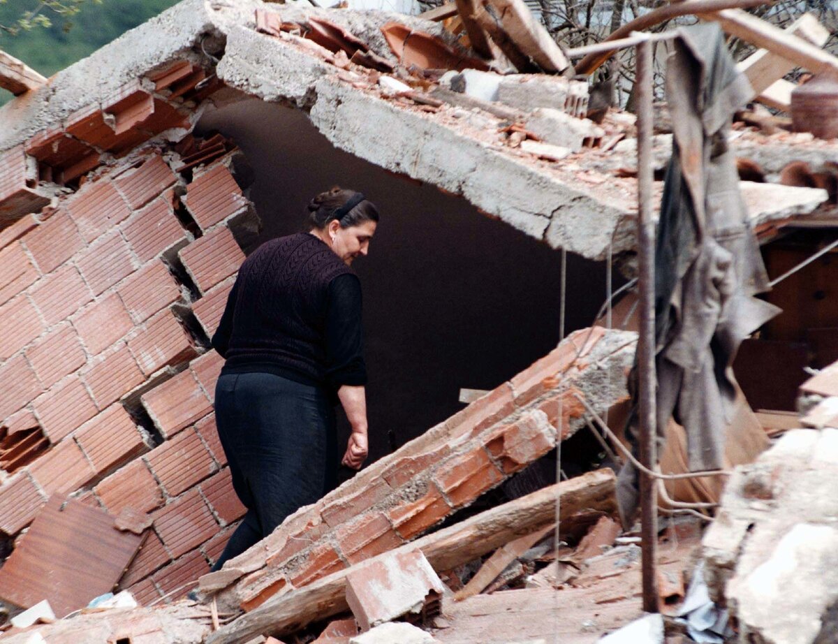 Женщина смотрит на руины своего дома в Сурдулице, 28 апреля 1999 года // AP Photo / STR