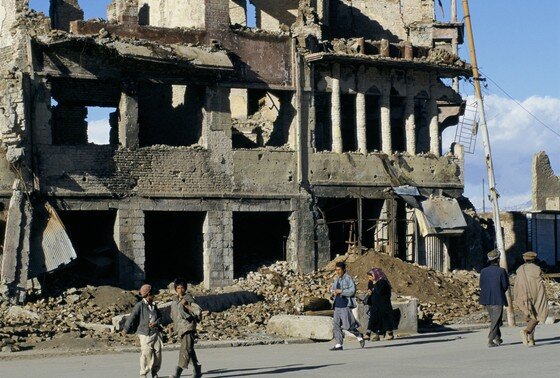    Люди идут по поврежденной войной улице в Кабуле, Афганистан