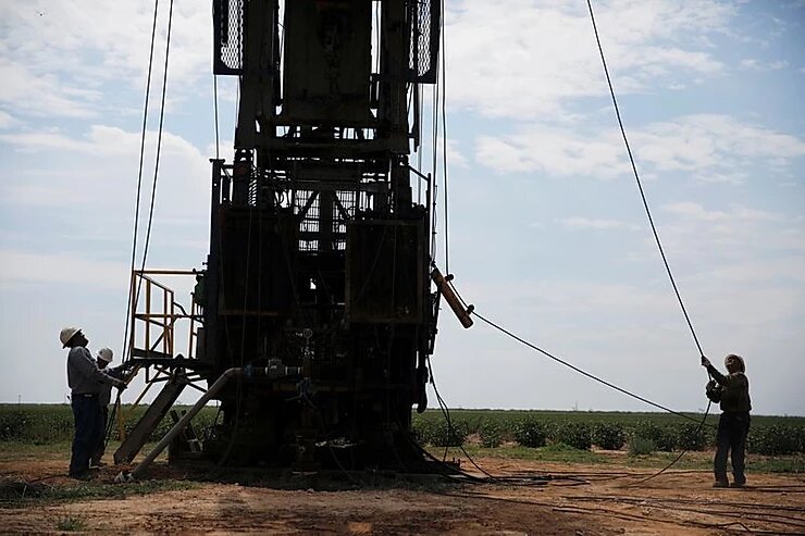 
ФОТОГРАФИЯ ФАЙЛА: Работники нефтепромысла готовят тампоны на хлопковом поле в Семиноле