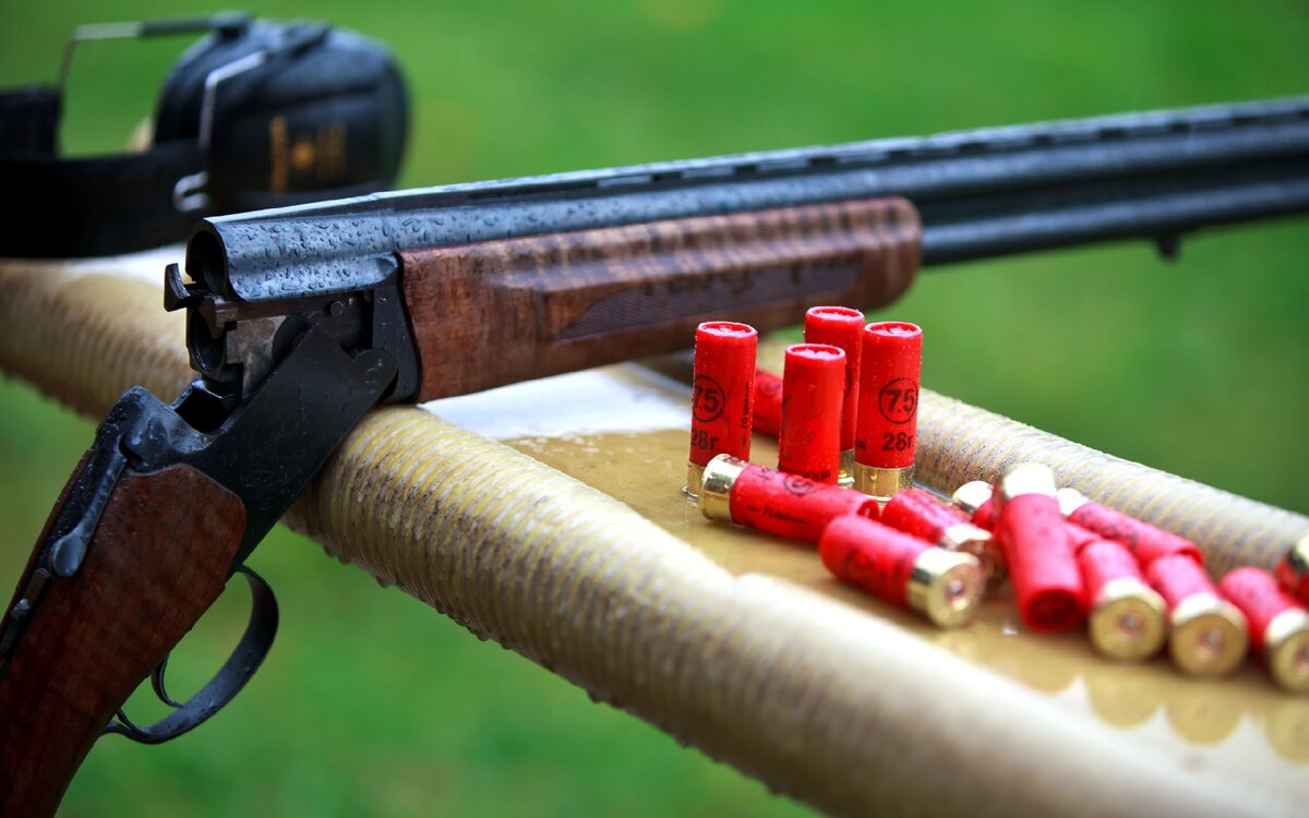 Ружьё и патроны на стендовом стрельбище. 