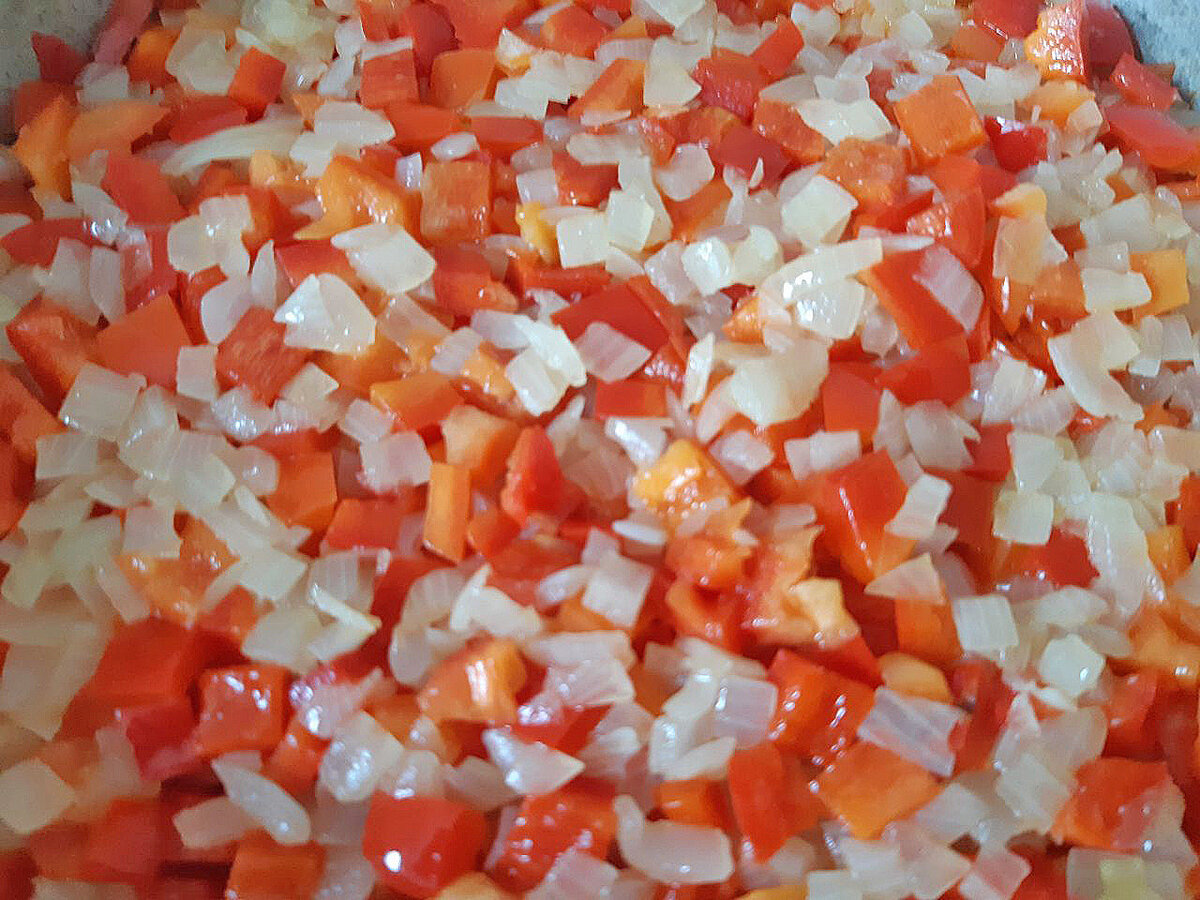 К пожаренному луку добавить нарезанный кубиками или соломкой перец