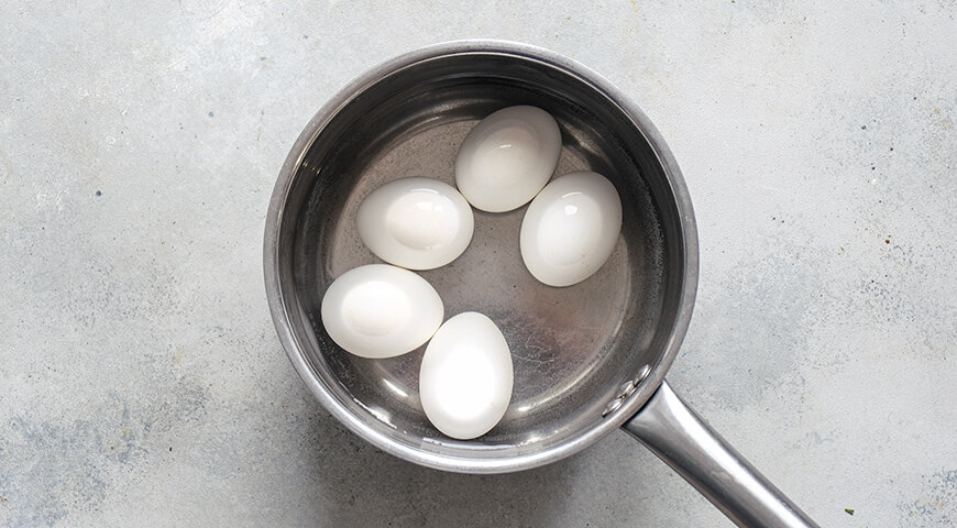 1. Подготовьте все ингредиенты закуски. Яйца вымойте и поместите в ковшик. Залейте холодной водой и доведите до кипения. Варите на среднем огне 10 минут, затем охладите проточной водой.