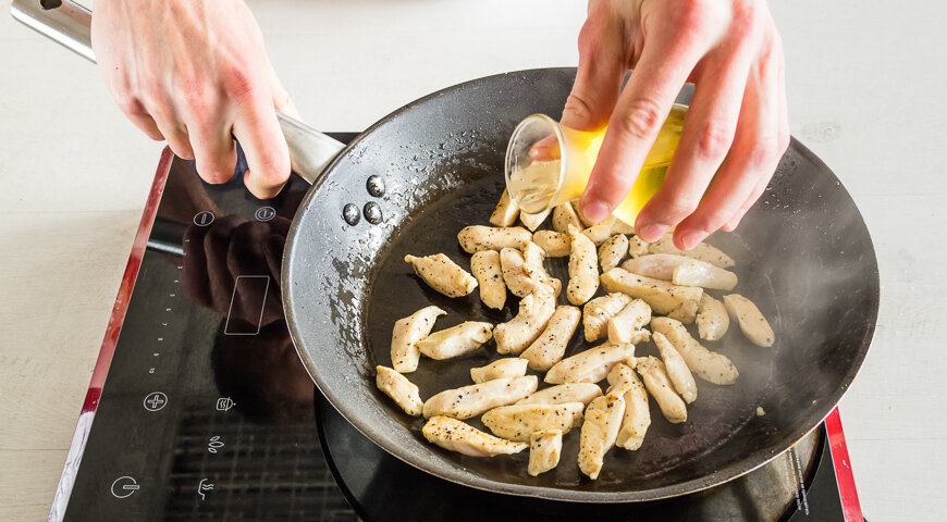 Подготовить ингредиенты салата. Куриное филе промыть, нарезать небольшими брусочками, посолить, поперчить и обжарить на оливковом масле, понемногу добавляя белое вино.