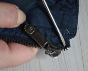 берём плоскогубцы и откусываем или снимаем верхний фиксатор бегунка (ограничитель, который не даёт собачке произвольно выпасть с молнии; откусывается пластмассовый, а разгибается и снимается – металлический);