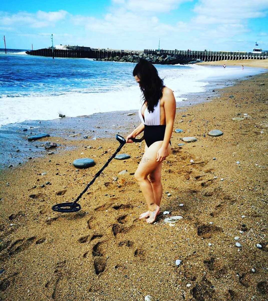 Девушка на пляже в поисках потерянных ювелирных украшений. Источник: Яндекс.Картинки.