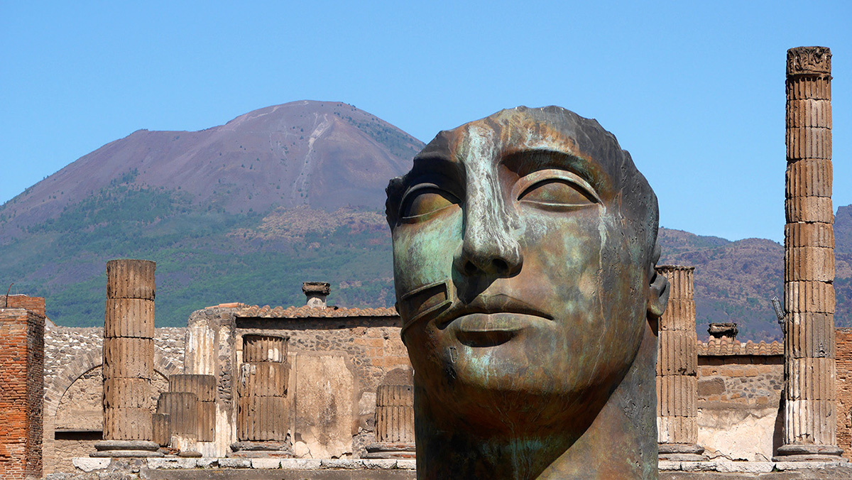 Помпеи. Один из бронзовых колоссов польского скульптора Игоря Миторая на фоне руин города. Фото с сайта lasottilelineadombra.com