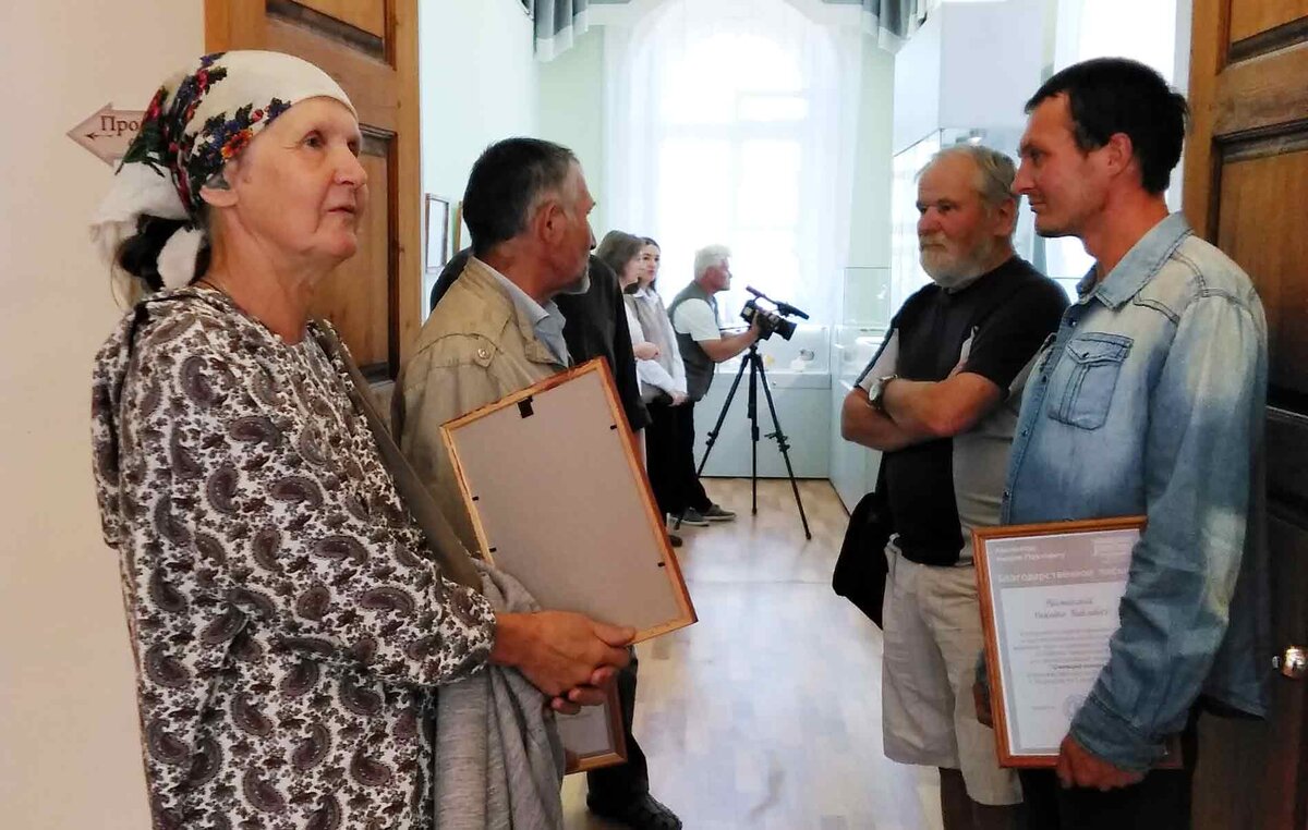 Елена и Павел Лесниковы, Степан Кривощёков и Никита Лесников у входа в выставочный зал