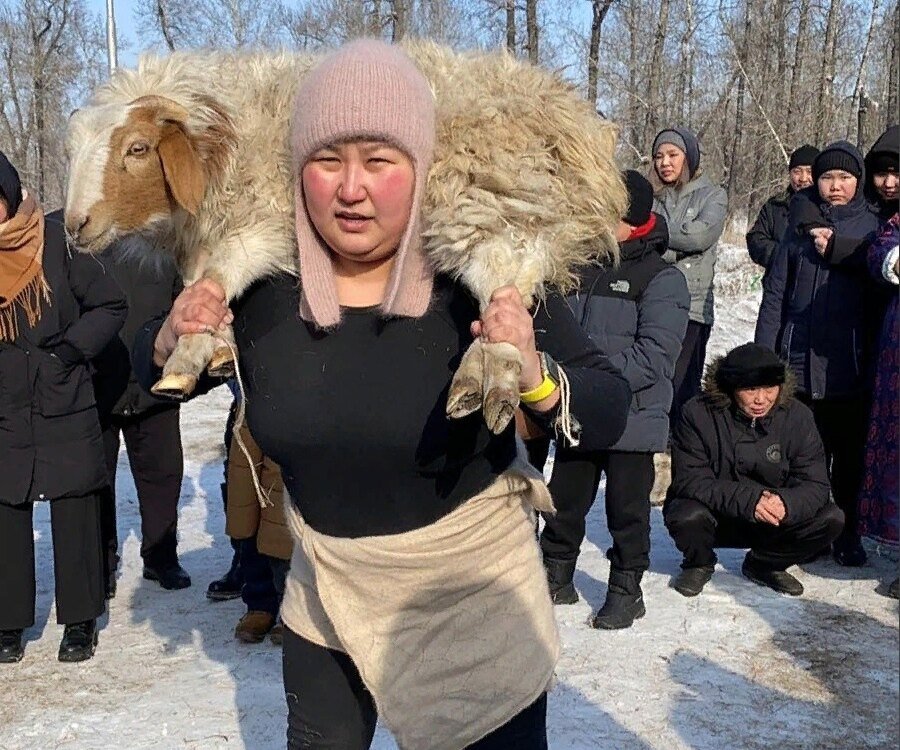     Жительница Тувы сделала 60 приседаний с бараном на плечах