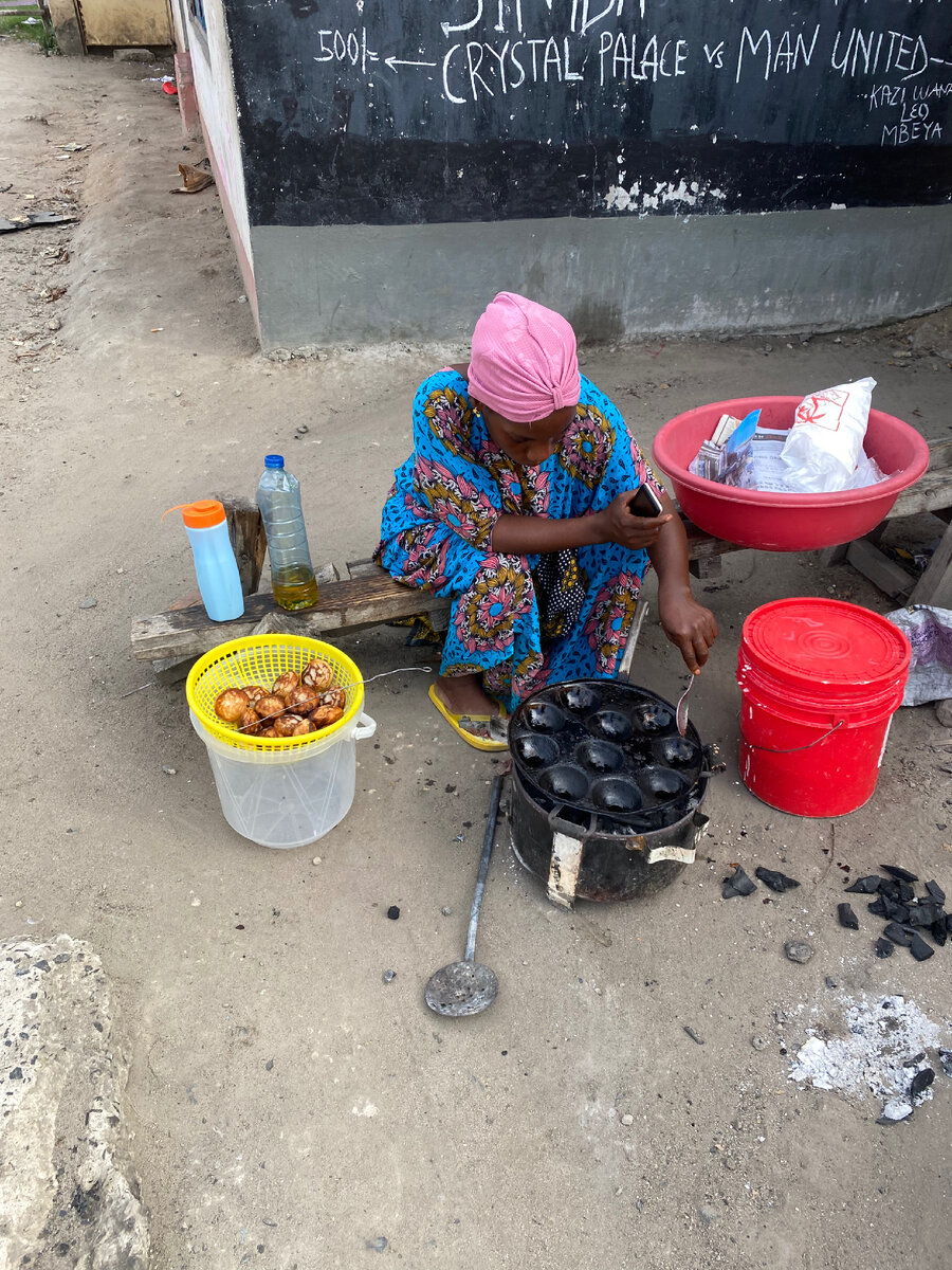 Печурка на углях, типичная танзанийская утренняя картина. «Женщина кормит людей» холст, масло.