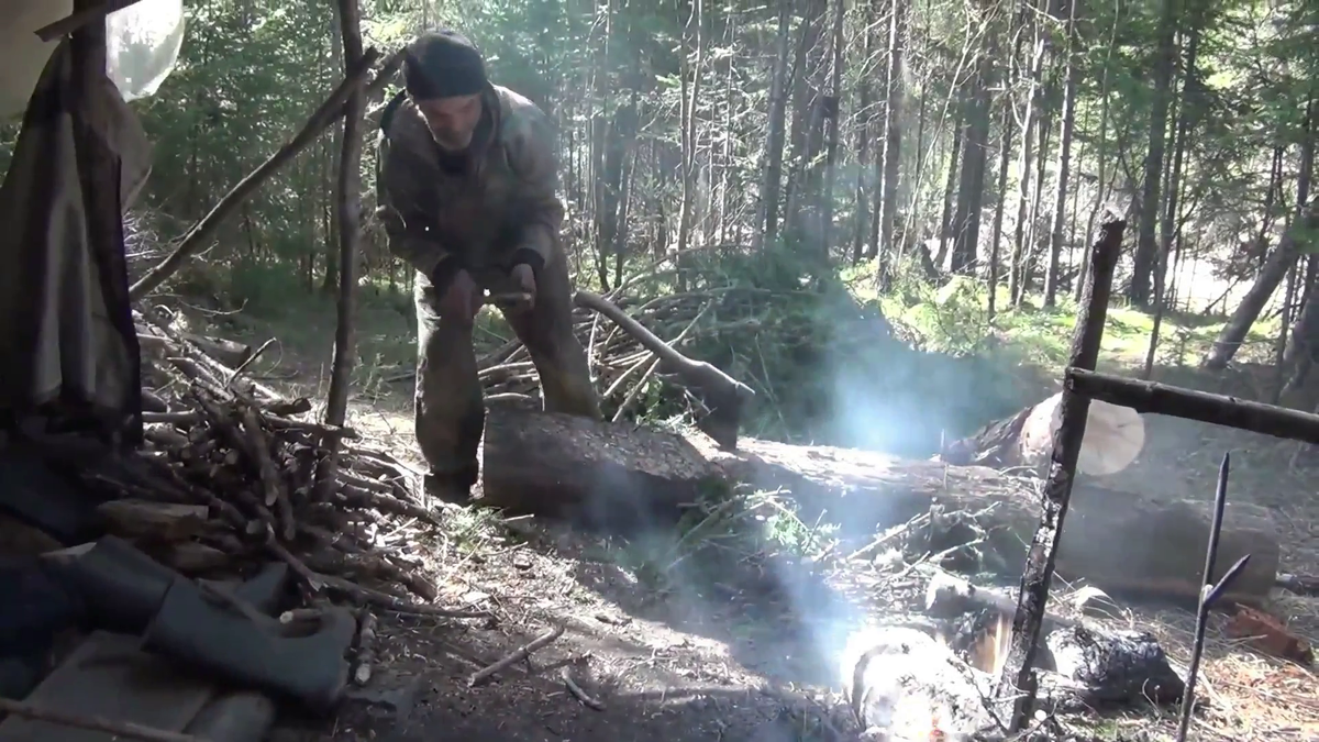 Федорович около шалаша рубит дрова в тайге - (смотрите на видео внизу статьи)