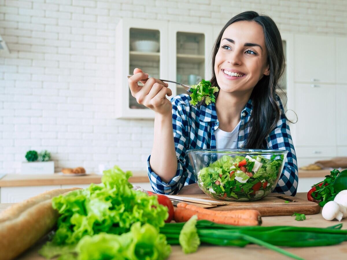    Девушка ест овощной салат© iStock.com / Povozniuk