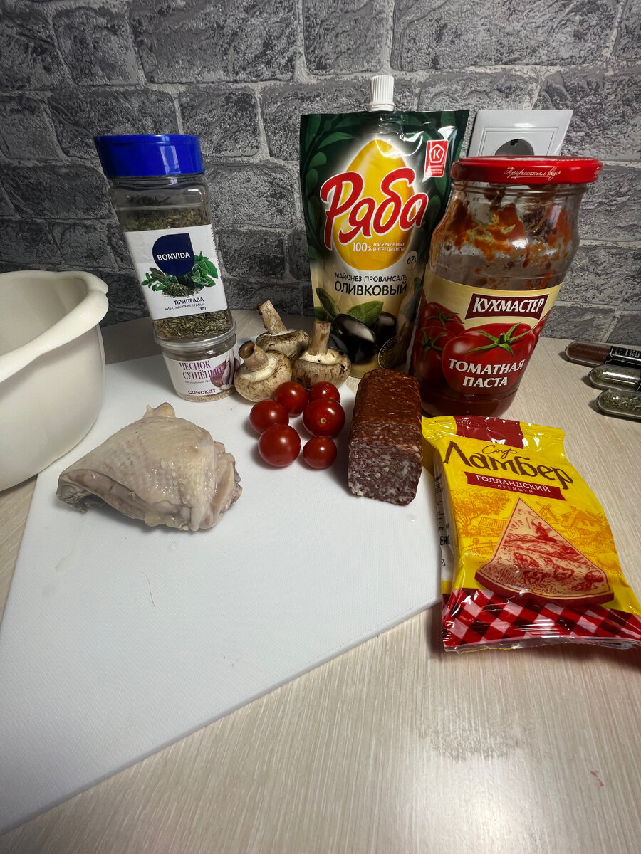 Приготовьте продукты для пиццы. Тесто достаньте из упаковки и оставьте размораживаться. Отварите филе курицы.