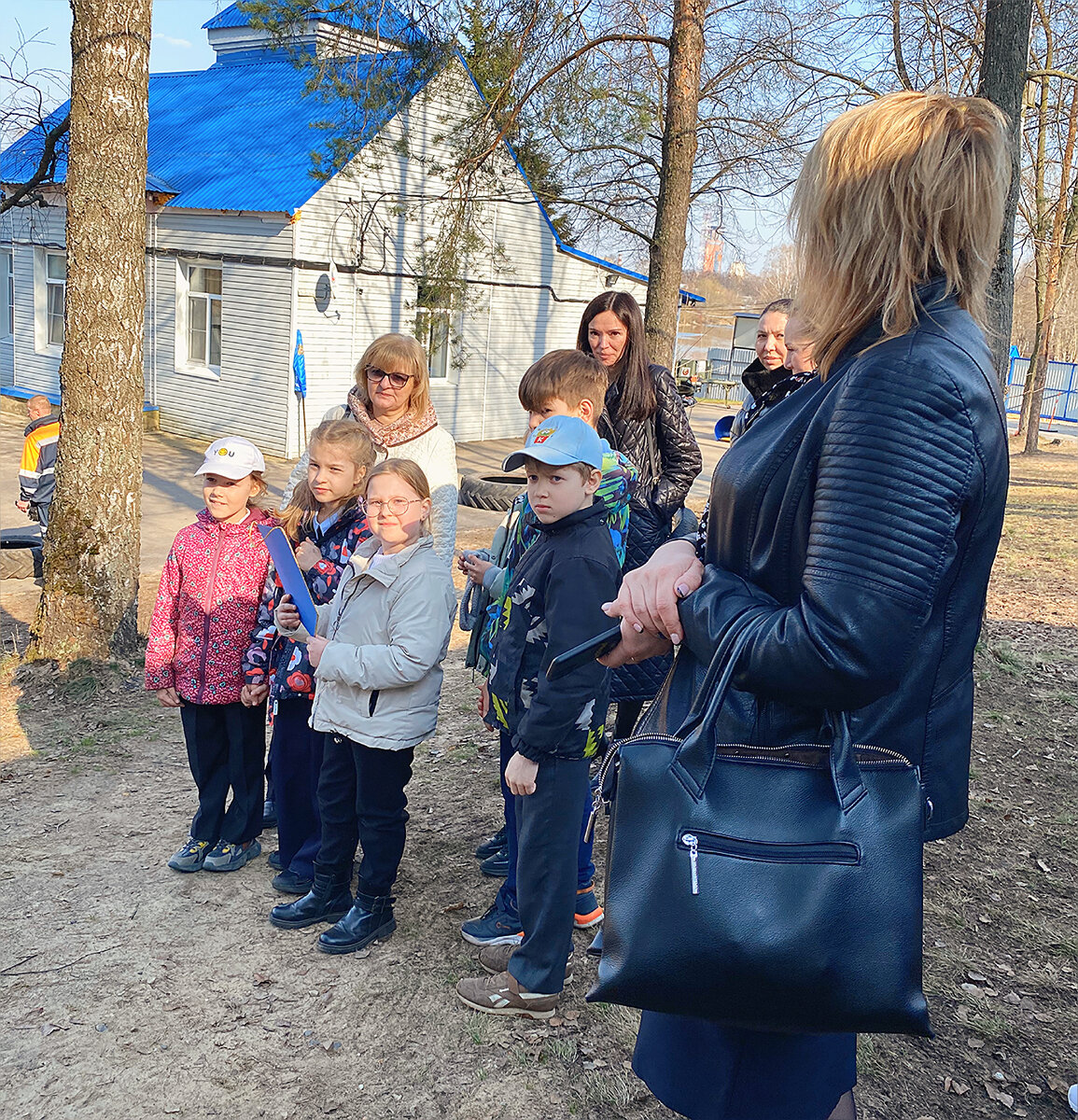 Василисса с синей папкой в руках