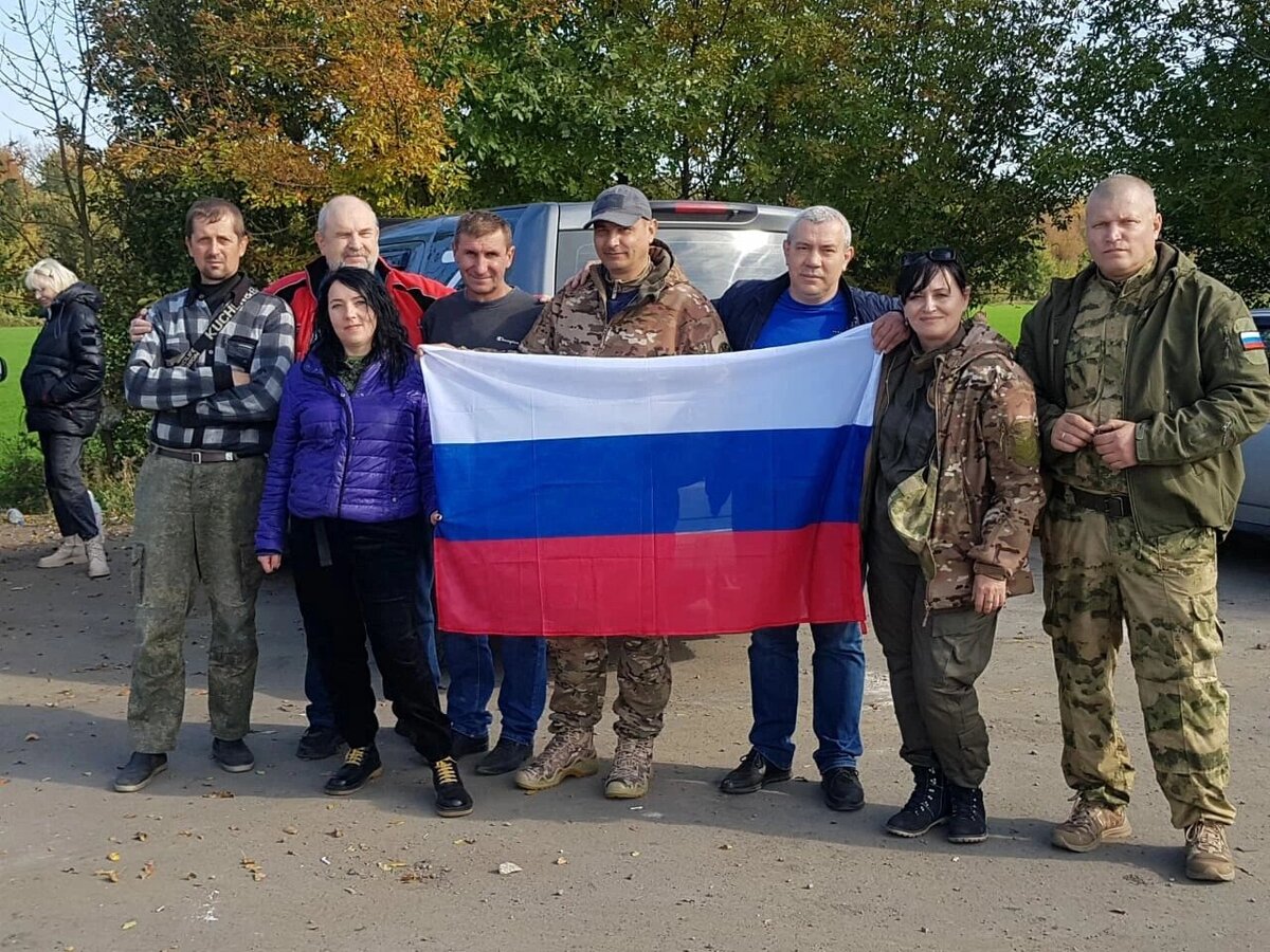 Илья Гусаров ( в синей футболке)  с супругой Жанной (в синей курточке), коллегами и бойцами...