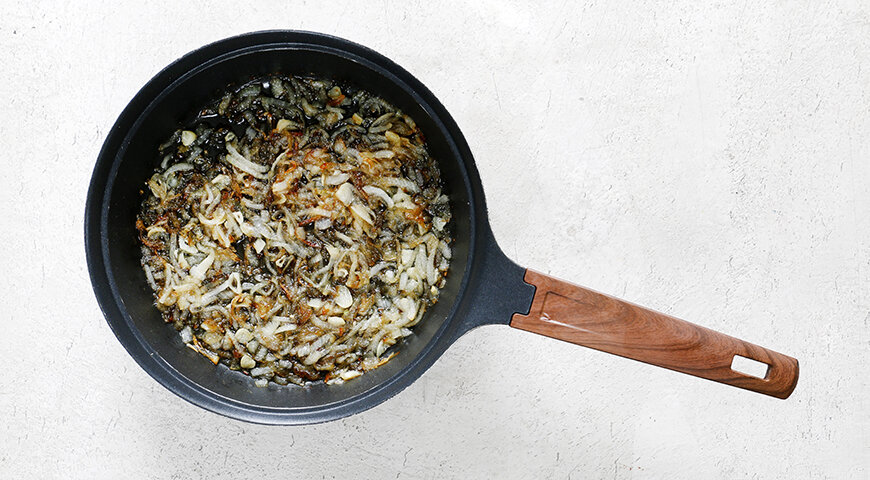 1. Для приготовления грудинки сначала очистите лук и нарежьте четвертинками колец. Чеснок очистите и нарежьте тонкими кружочками. Разогрейте масло в небольшой кастрюльке до 180°С и сложите в кастрюльку лук и чеснок. Обжаривайте до коричневого цвета, затем откиньте на сито и дайте маслу полностью стечь. Масло не выбрасывайте! (см. совет).