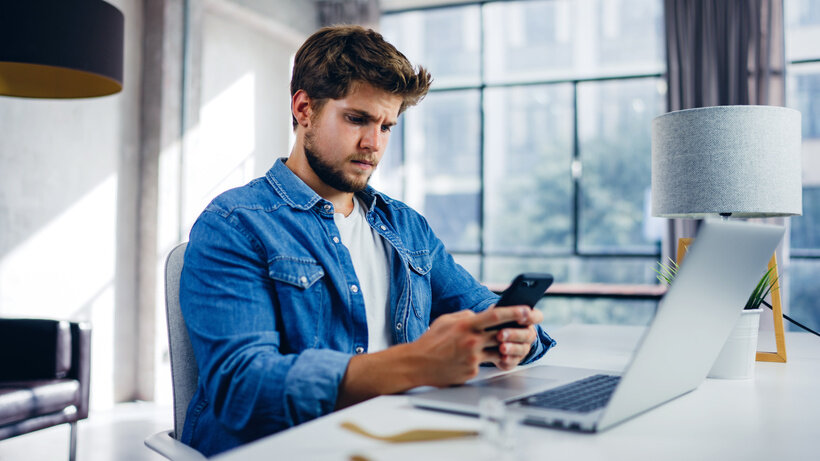    Мужчина с телефоном и ноутбуком © Adobe Stock