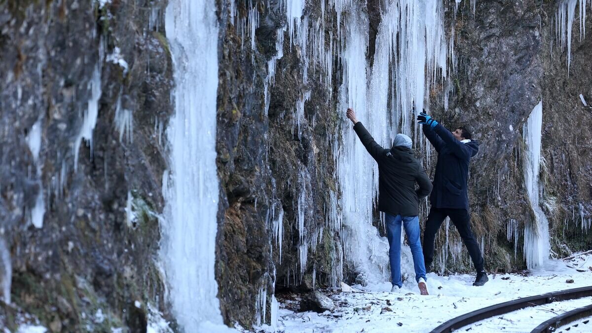    Туристы на узкоколейной железной дороге в Гуамском ущелье, замерзшем из-за сильных морозов, в Краснодарском крае© РИА Новости / Виталий Тимкив