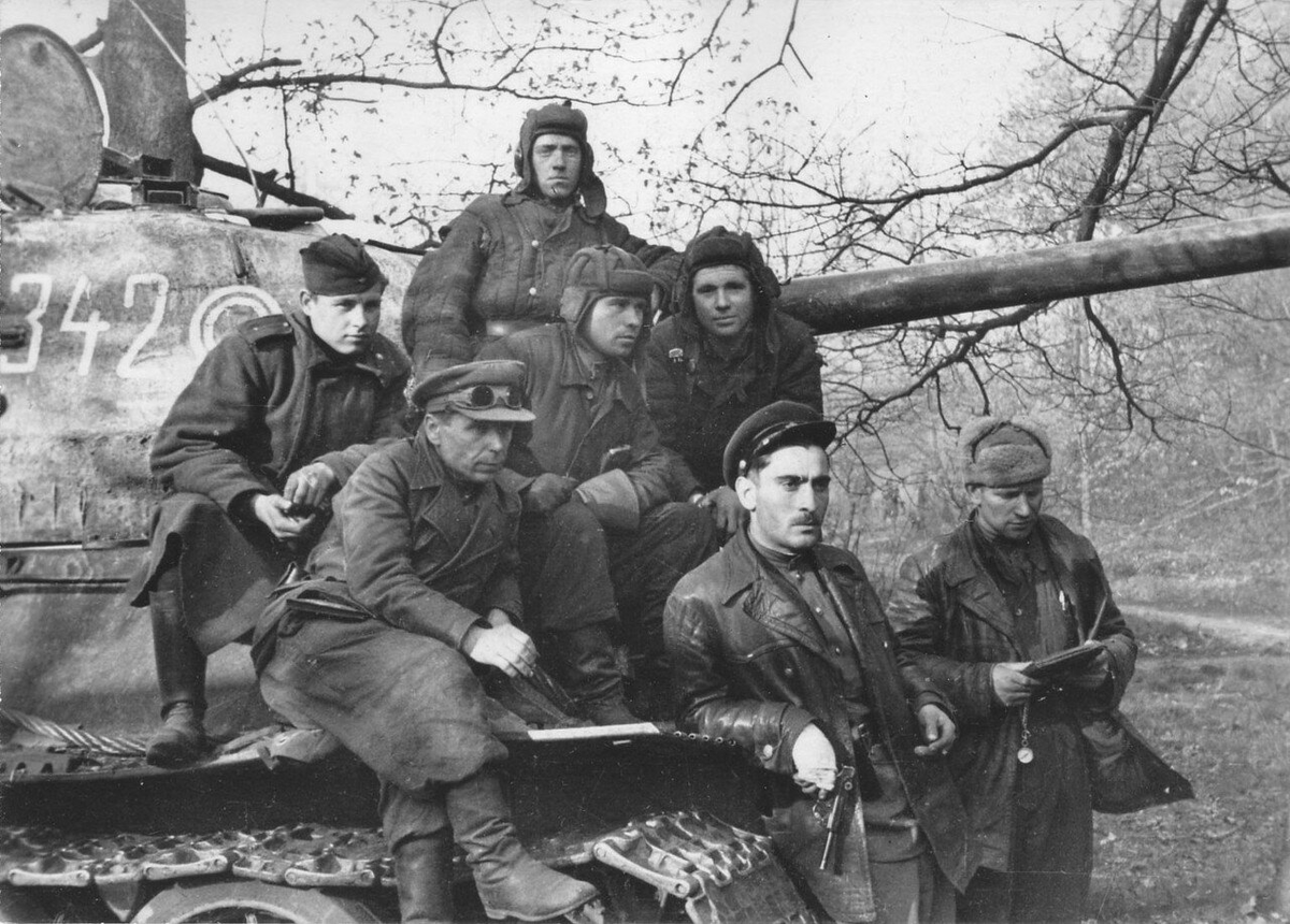  Бойцы и командиры 7-го гвардейского танкового корпуса у танка Т-34-85 с экипажем в Берлине.