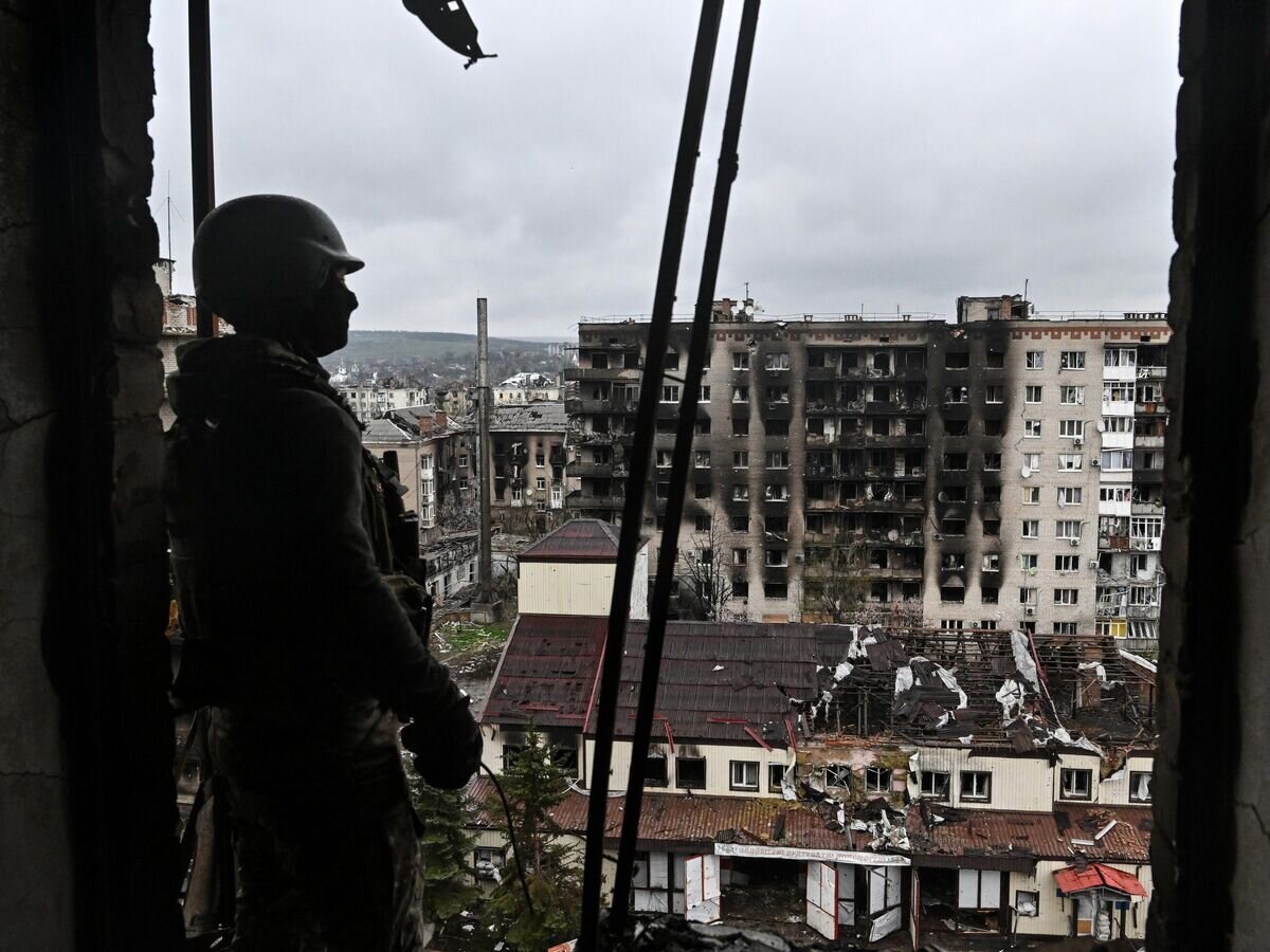    Боец ЧВК "Вагнер" осматривает разрушенный район Артемовска© РИА Новости / Евгений Биятов