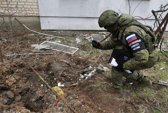    Сотрудник Следственного комитета России проводит следственные действия у жилого многоквартирного дома в Мелитополе