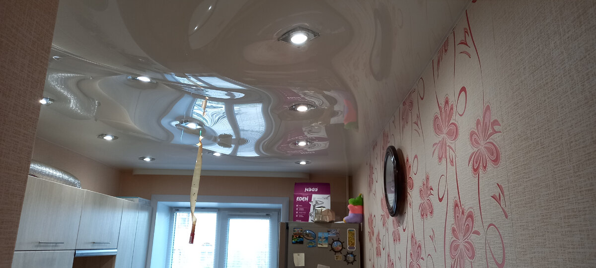 Кухня только что затопленной квартиры, сухие обои, на холодильнике стоят сухие коробки, горит свет