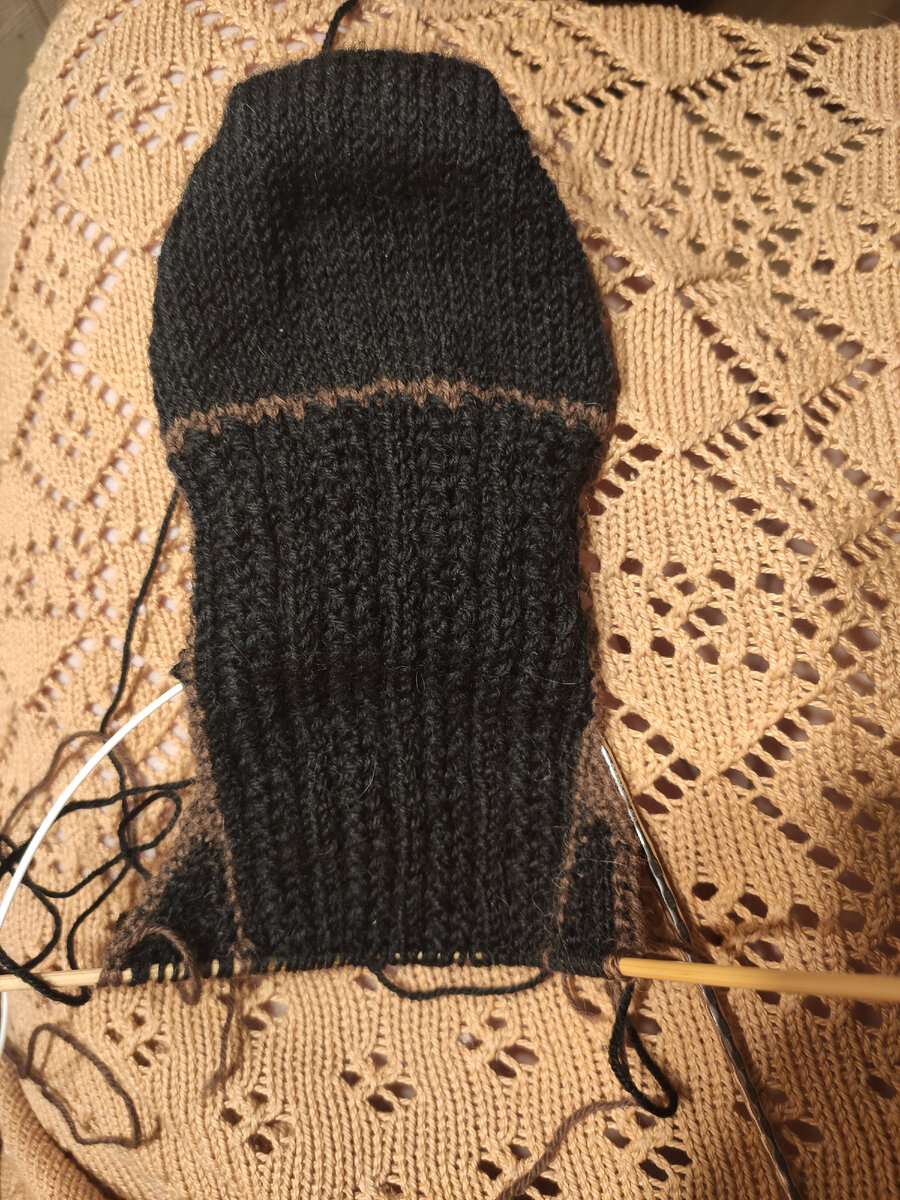 На фото один из этапов вязания чёрного гольфа с началом от мыска. Коричневой пряжей очерчены границы отдельно связанных поворотным способом участков: верх носка с подъёмом, клинья подъёма (связаны отдельно больше ради оригинальности), низ носка- подошва с пяткой. Места быстрого износа можно будет заменить, связав их заново.