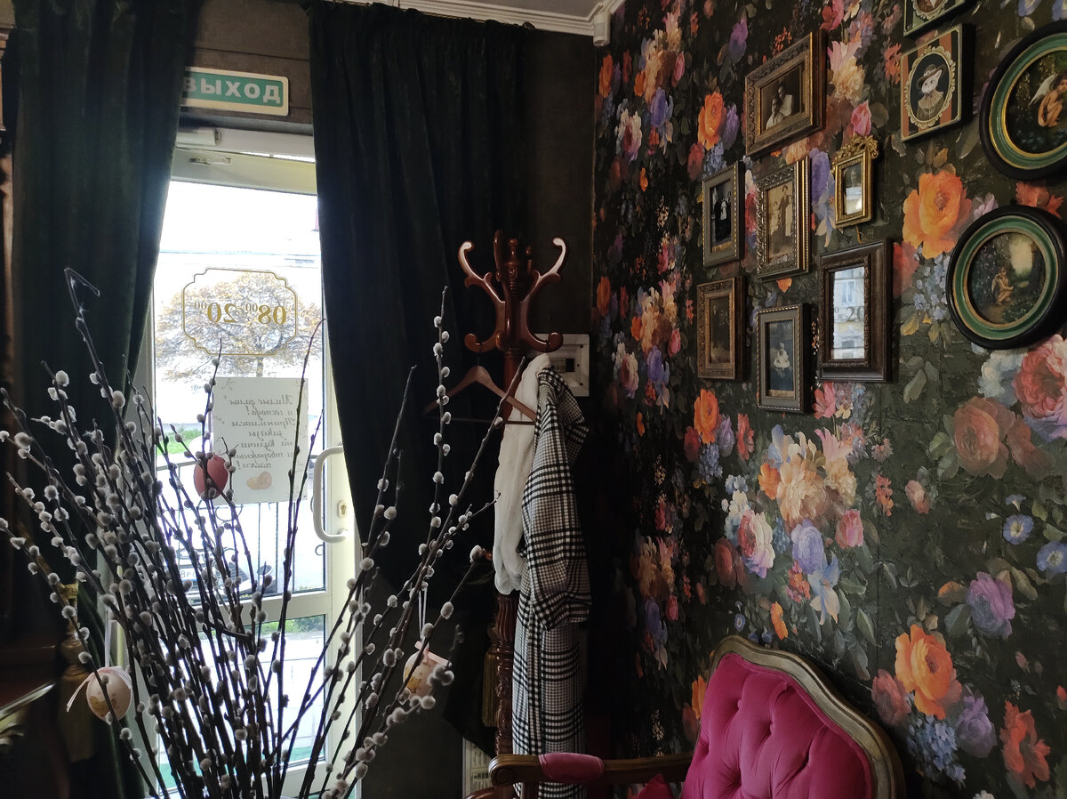 На входе винтажная вешалка, на стене фотографии и открытки в стиле ретро