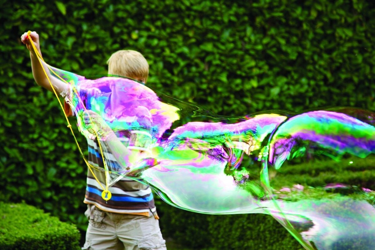 Гигантские пузыри образуются из-за взаимодействия молекул мыльного раствора, которые создают поверхностное напряжение. Когда вы создаете пленку из раствора на кольце (или с помощью рук), воздушные пузыри оказываются запечатанными внутри, что позволяет пузырям оставаться великолепно большими и легко парить в воздухе.