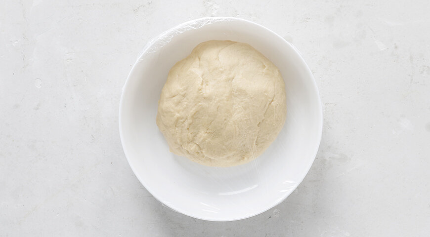 1. Замесите тесто для пирога с тремя начинками. В чаше миксера смешайте все ингредиенты теста, кроме сахара и масла. Замесите до объединения ингредиентов. Увеличьте скорость замеса и добавьте 1/3 сахара. Когда тесто начнёт приобретать эластичность, добавьте в два приёма оставшийся сахар. В конце замеса постепенно, небольшими порциями, введите сливочное масло. Вымешанное тесто будет гладким и эластичным. Переложите тесто в контейнер или большую миску, накройте крышкой и оставьте для брожения на 2 часа при комнатной температуры. Через час от начала брожения обомните тесто.