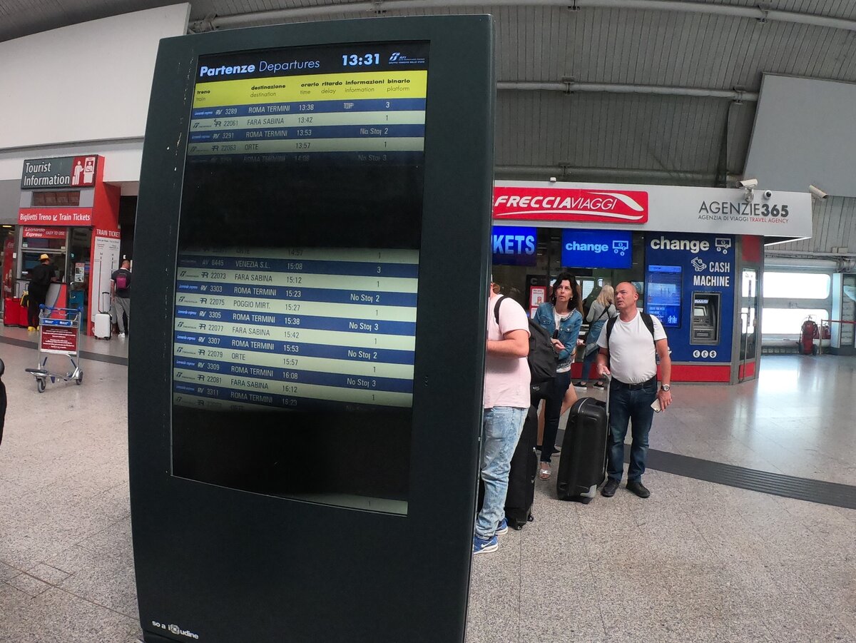 Информационное табло отправлений и касса на заднем плане