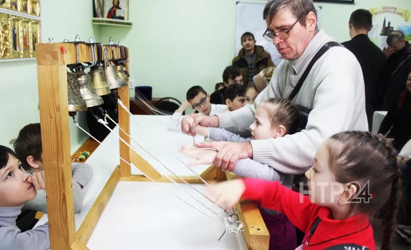    Леонид объясняет и показывает, как правильно тянуть за веревки, направляет руки детей, следит за ритмом // Фото автора
