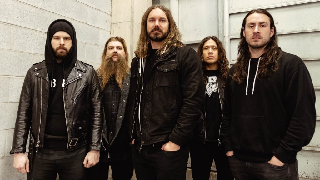 As I Lay Dying в 2019 году — Ламбезис в центре. В 2022 году большая часть состава покинет группу и Ламбезис останется её единственным оригинальным участником