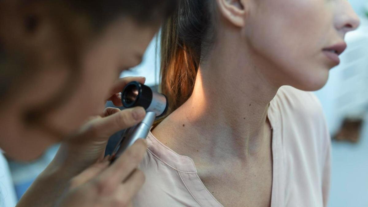    Дерматолог изучает новообразования на коже девушки:Freepik