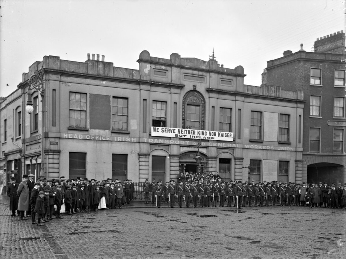 1914 год. Члены Ирландской гражданской армии у входа в  Liberty Hall под лозунгом «Мы не служим королю, ни кайзеру, но Ирландии »