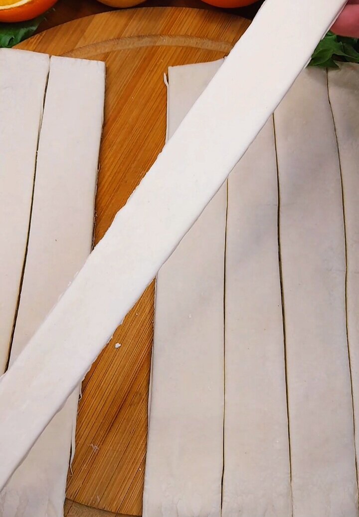 2. Слоёное дрожжевое тесто раскатаем , разрезаем на полоски, и немного растягиваем в длину ...