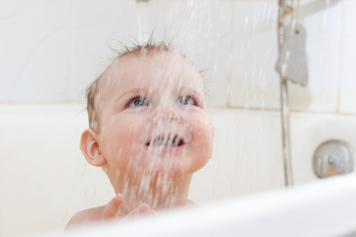 Ребенок умывается. Купание малыша. Водные процедуры закаливание. Дети брызгаются водой. Девочки в ванне.