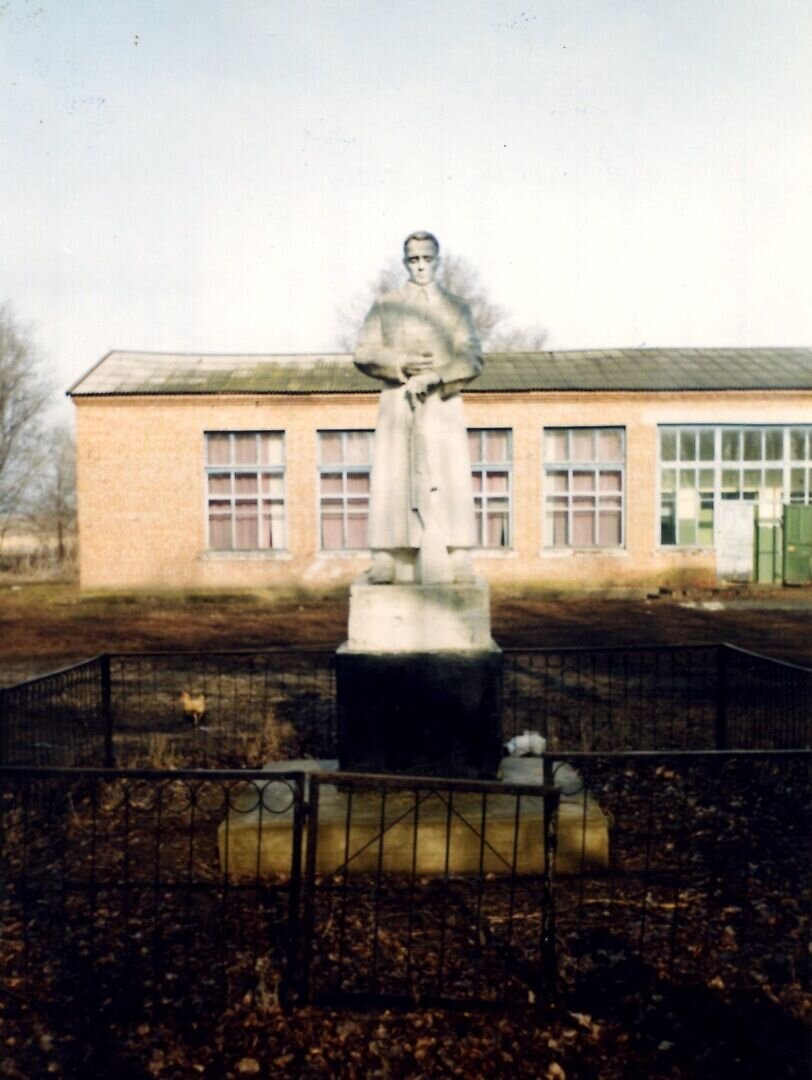 памятник погибшим землякам, а за ним здание клуба