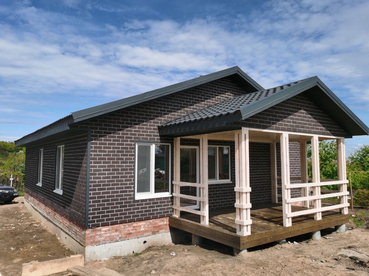 Дом из сип-панелей с фасадной плиткой DOCKE. Дом стоит на свайно-ростверковом с пустотой плитой перекрытия