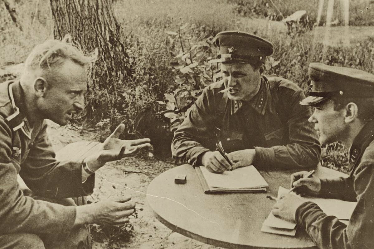 Допрос фашиста. Военный переводчик офицер русский. Военный переводчик фото. Два фашиста сидят за столом.