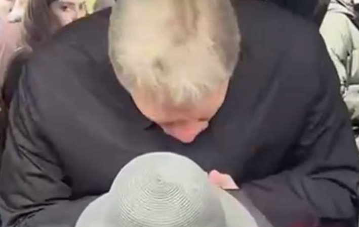 Дмитрий Песков склонился над женщиной в шляпе. Фрагмент фото из Интернета.