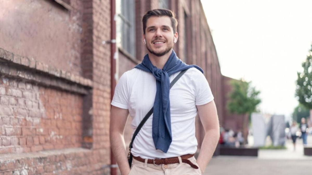    Мужчина в наушниках идет по улице:Freepik