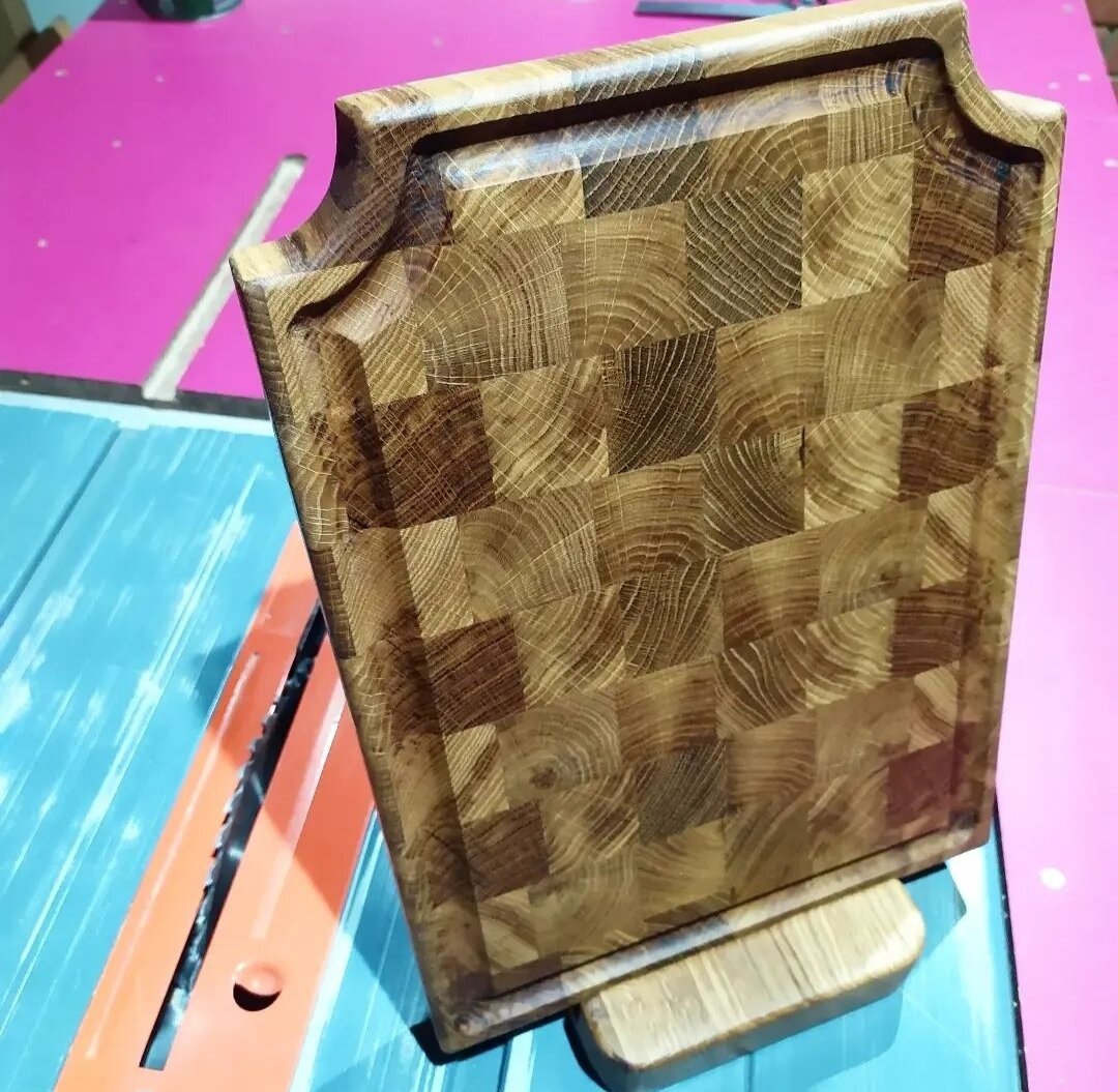 Процесс создания подобной разделочной доски довольно трудоёмкий и затратный, потому  подобные изделия зачастую стоят довольно дорого (Если вы конечно не работаете в столярном цехе предприятия) . Перед тем как изготовить подобную вещь, необходимо подобрать материал. Естественно сухой и без явных дефектов. В данном случае это дуб. Дуб известен своими сюрпризами в виде внутренних трещин, потому при подготовке приходится тщательно просматривать заготовку, ну как правило при распиловке что нибудь да вылезет. Распиловка, склейка, сушка, выравнивание на рейсмусе, подравнивание краев, окончательная шлифовка. Без минимального набора станков вряд ли получится сделать подобную доску. Но... в результате когда передаешь изделие клиенту или в виде подарка и видишь не поддельную радость и восторг в глазах, то испытываешь огромное удовлетворение от своей работы и понимаешь что не зря. 