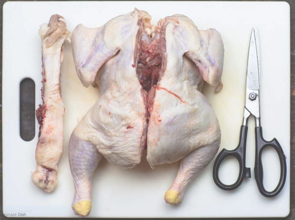  Главное – правильно подготовить курицу. Теперь ее надо правильно распластать, но не так, как для цыпленка табака. И режьте не поперек куриной грудки, как для табака, а вот так: удалите хребет, разрезав курицу вдоль с обеих сторон.